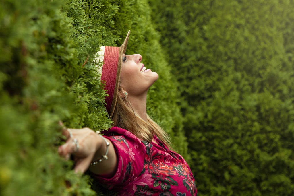 A joyful woman enjoying nature, embracing freedom in a lush green park.