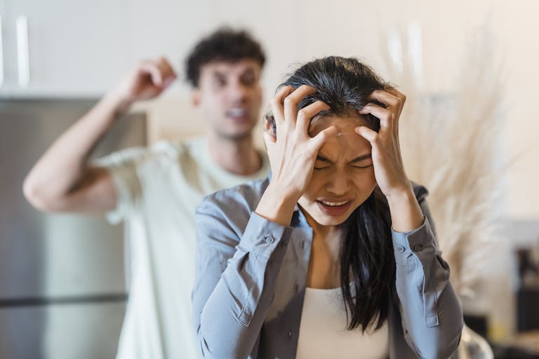 An upset couple arguing in a kitchen, highlighting stress and frustration in relationships.