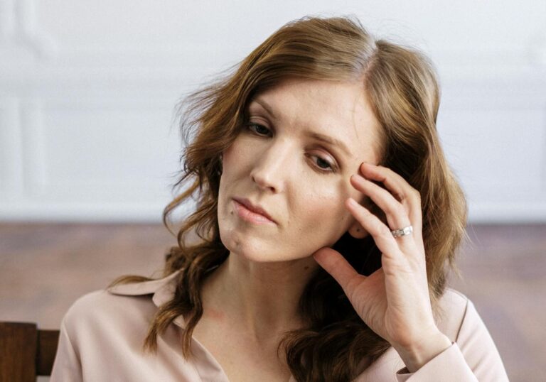 Portrait of a thoughtful woman sitting in an office setting, deep in reflection and contemplation.