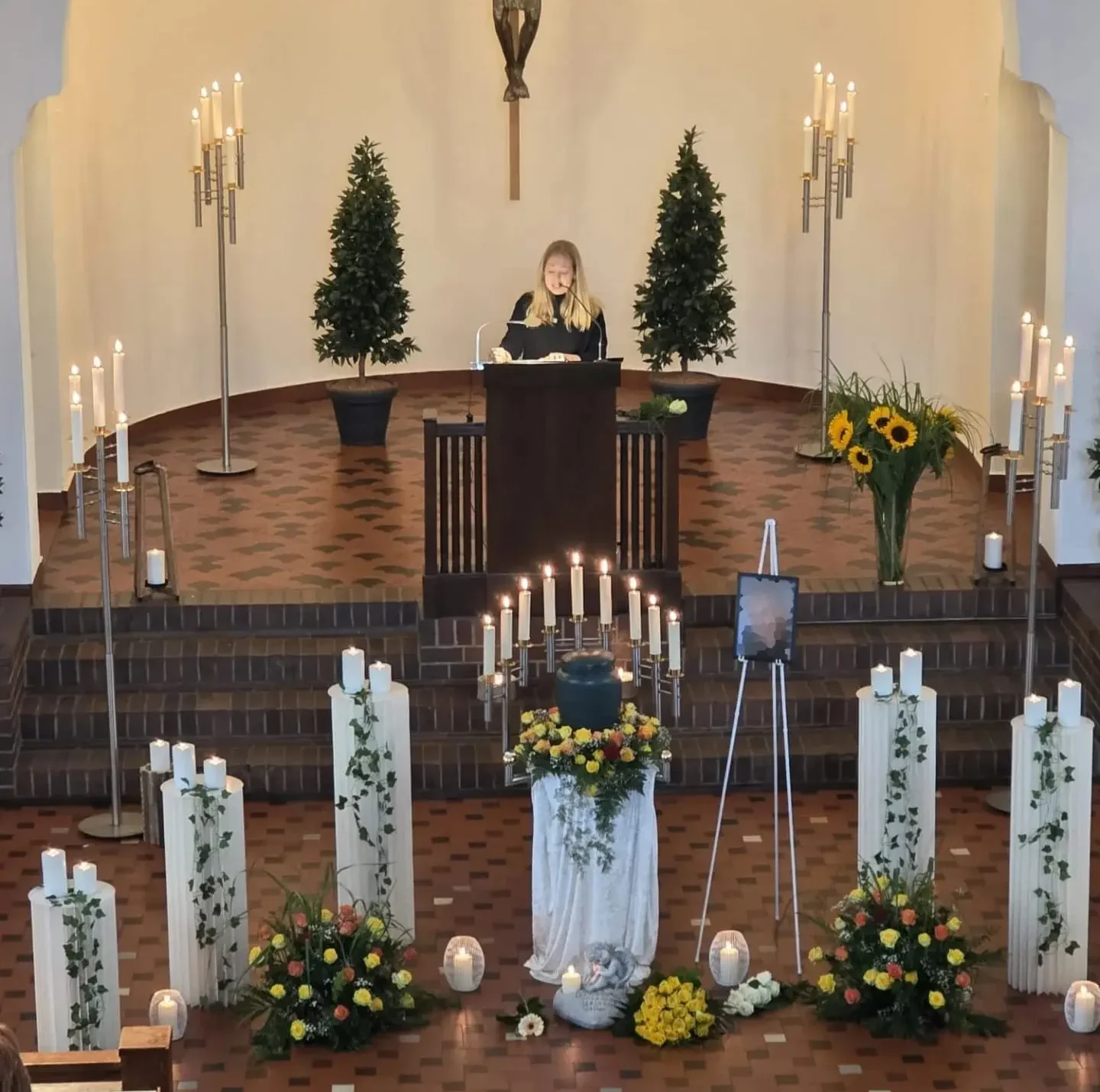 Trauerrednerin Sarah Riedel hält eine persönliche Trauerrede am Redepult bei einer Trauerfeier in Hamburg.